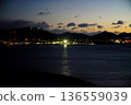 Night view of a port town, the sea at dusk, silhouettes of mountains, illuminated bridges, and reflections on the water Night view of a port town, the sea at dusk, silhouettes of mountains, illuminated bridges, and reflections on the water 136559039