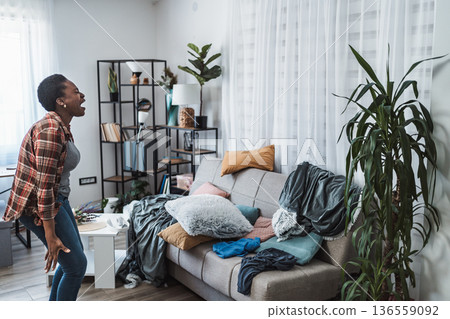 Young woman screaming because her apartment is a mess Young woman screaming because her apartment is a mess 136559092