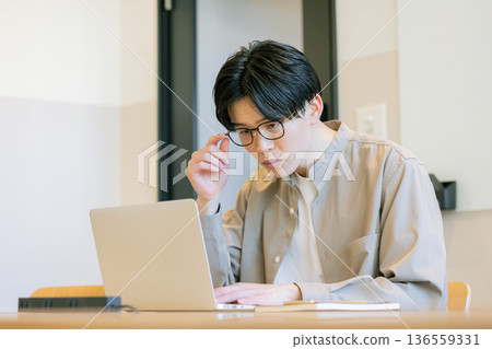 Man operating laptop at cafe Man operating laptop at cafe 136559331