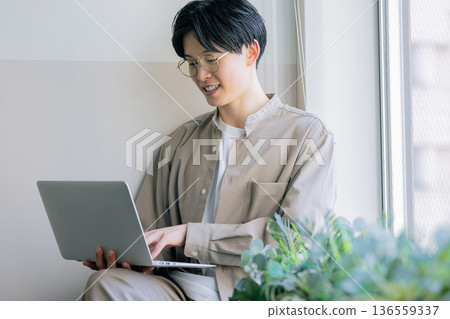 一個在家裡用電腦工作的人 136559337