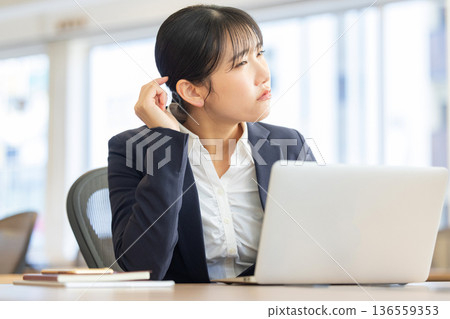 Worried woman looking at computer screen 136559353