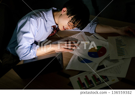 Businessman feeling tired after working overtime Businessman feeling tired after working overtime 136559382