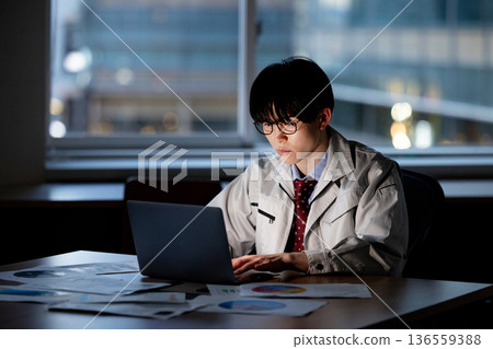 A man in work clothes working overtime 136559388