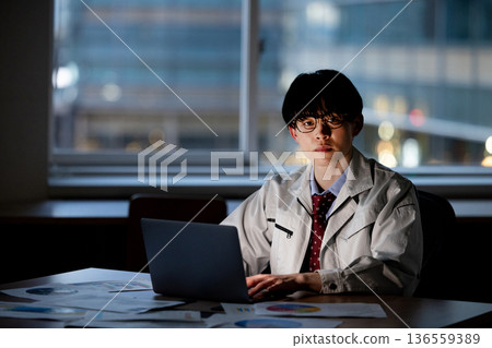 一名身穿工作服的男子正在加班 136559389