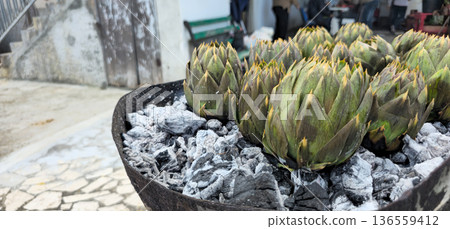 Close up view of Artichoke roasting in a barbecue with carbon Close up view of Artichoke roasting in a barbecue with carbon 136559412