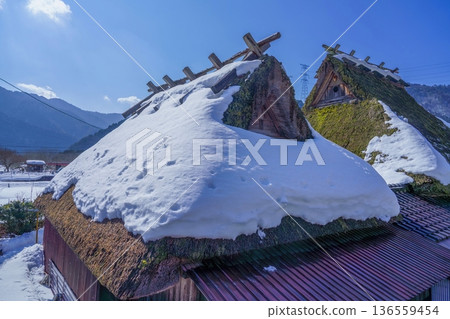 Traditional Japanese thatched roof house covered in snow, Miyama, Kyoto in winter Traditional Japanese thatched roof house covered in snow, Miyama, Kyoto in winter 136559454
