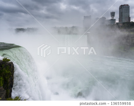Niagara Falls, with its spectacular spray rising from the water - view from the American side Niagara Falls, with its spectacular spray rising from the water - view from the American side 136559938