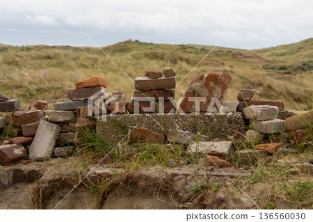 Stack of stone bricks as still life in the dune landscape Stack of stone bricks as still life in the dune landscape 136560030
