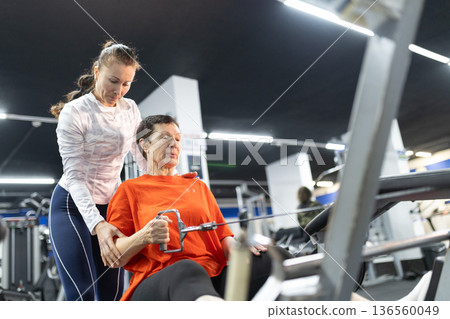 Senior woman training with personal fitness trainer 136560049