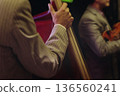 Concert view of contrabass violoncello player with vocalist and musical band during string concert, jazz orchestra performing music, violoncellist cello jazz player on stage in club, music arena hall 136560241
