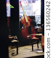 Concert view of contrabass violoncello player with vocalist and musical band during string concert, jazz orchestra performing music, violoncellist cello jazz player on stage in club, music arena hall 136560242