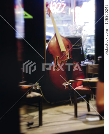 Concert view of contrabass violoncello player with vocalist and musical band during string concert, jazz orchestra performing music, violoncellist cello jazz player on stage in club, music arena hall 136560242