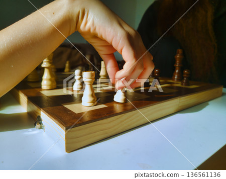 Budapest Family Home Chess Game Final Move with Child Hand in Focus on Wooden Board under Warm Morning Light Interior Lifestyle Photography Hungary Residential Zuglo District Budapest Family Home Chess Game Final Move with Child Hand in Focus on Wooden Board under Warm Morning Light Interior Lifestyle Photography Hungary Residential Zuglo District 136561136