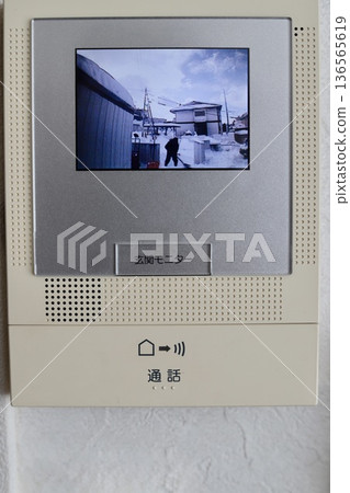 透過對講機監視器可以看到一名男子正在鏟雪。 透過對講機監視器可以看到一名男子正在鏟雪。 136565619