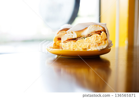 Bagel bread with scrambled egg and bacon. 136565871