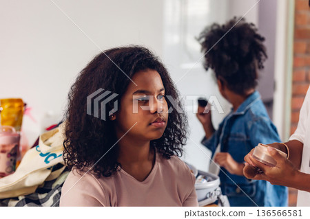 Stylist is putting make up on black woman eyebrows with the eyebrows brush. 136566581