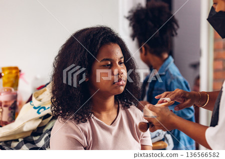 Stylist is putting make up on black woman eyebrows with the eyebrows brush. Stylist is putting make up on black woman eyebrows with the eyebrows brush. 136566582