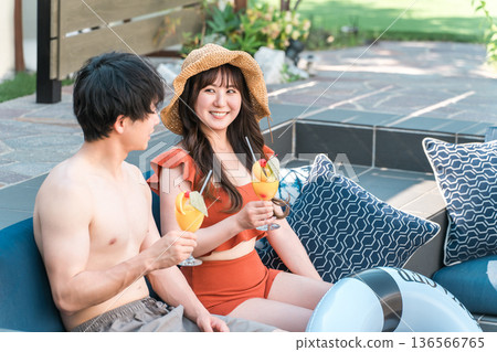 Asian couple in swimwear relaxing in a jacuzzi by the pool Asian couple in swimwear relaxing in a jacuzzi by the pool 136566765