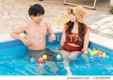 一對年輕的亞洲夫婦在度假勝地的泳池玩耍 136566896