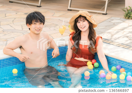 一對年輕的亞洲夫婦在度假勝地的泳池玩耍 136566897