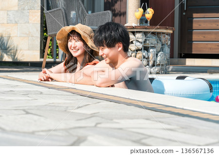 一對年輕的亞洲夫婦在度假勝地的泳池玩耍 136567136