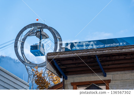 A blue gondola passes a circular structure on a clear blue sky. Zermatt, Valais, Switzerland A blue gondola passes a circular structure on a clear blue sky. Zermatt, Valais, Switzerland 136567302