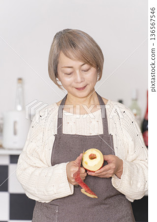 老婦人在廚房削蘋果 老婦人在廚房削蘋果 136567546