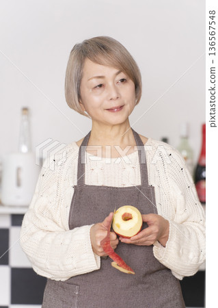 老婦人在廚房削蘋果 136567548
