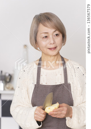 老婦人在廚房削蘋果 136567579
