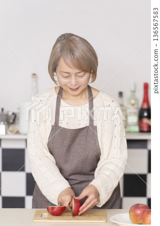 老婦人在廚房削蘋果 136567583