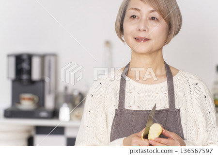 老婦人在廚房削蘋果 136567597