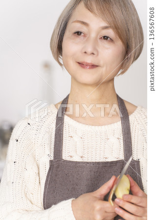 老婦人在廚房削蘋果 136567608