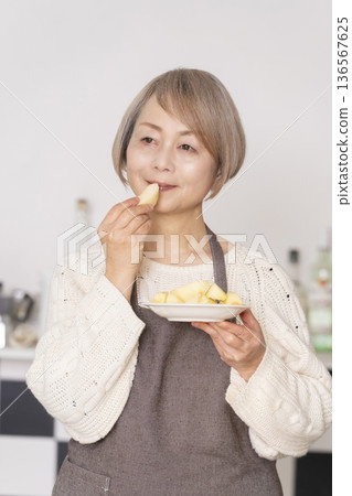 老婦人在廚房削蘋果 老婦人在廚房削蘋果 136567625