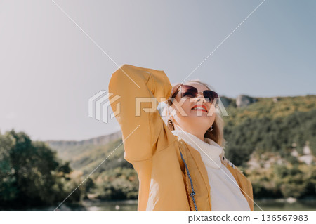 Woman in Yellow Jacket, Looking Up at the Mountains Woman in Yellow Jacket, Looking Up at the Mountains 136567983
