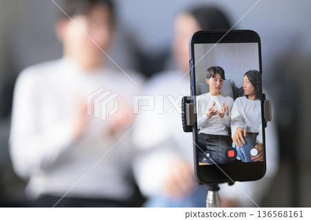 Men and women streaming videos at home 136568161