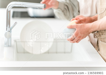 一個男人在水槽裡洗碗的手 136569901