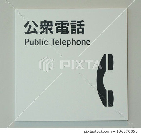 Public telephone sign posted on the wall of a public facility building 136570053