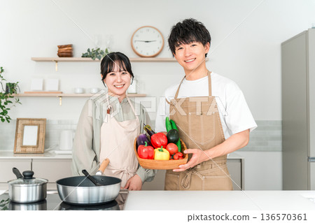 Young Asian man and woman holding vegetables in the kitchen, couple, husband and wife Young Asian man and woman holding vegetables in the kitchen, couple, husband and wife 136570361