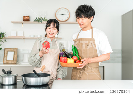 Young Asian man and woman holding vegetables in the kitchen, couple, husband and wife 136570364