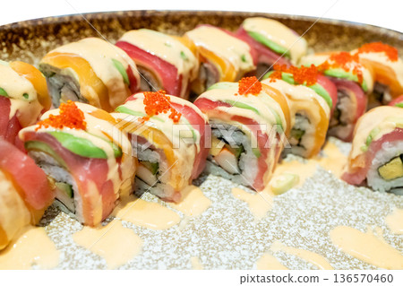 Top view of Seared salmon sushi roll with spicy sauce, focus selective 136570460