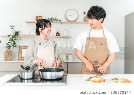 一對年輕的亞洲夫婦在廚房做飯 一對年輕的亞洲夫婦在廚房做飯 136570544
