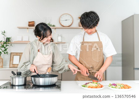 一對年輕的亞洲夫婦在廚房做飯 一對年輕的亞洲夫婦在廚房做飯 136570546