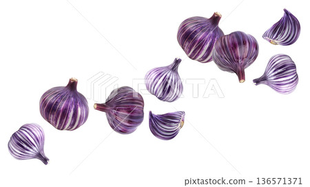 Multiple striped purple onions and slices isolated on white background, food concept emphasizing color and texture 136571371