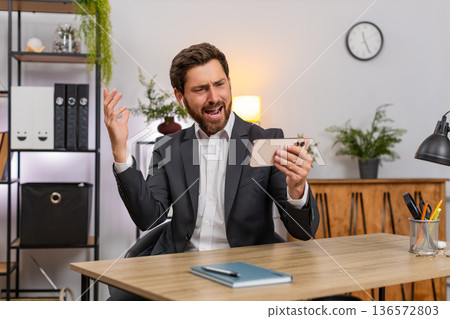Middle-aged businessman watches clip on smartphone wearing wireless headphones dancing laughing fun 136572803