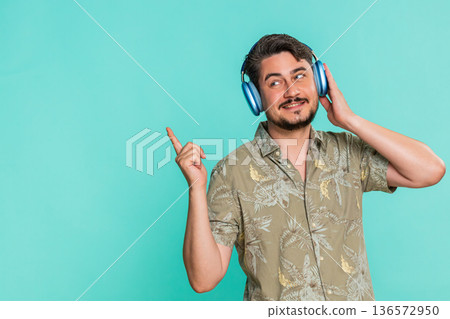 Adult man enjoying music in headphones rhythmically moving head expressing satisfaction dancing Adult man enjoying music in headphones rhythmically moving head expressing satisfaction dancing 136572950