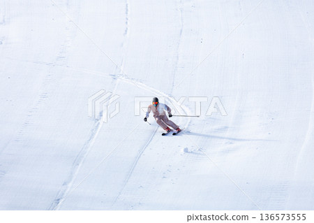 Skiers drawing tracks on the slopes 136573555