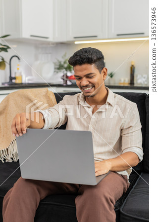 Indian man opens laptop starts project launches app begins typing with focus and sets new task list Indian man opens laptop starts project launches app begins typing with focus and sets new task list 136573946