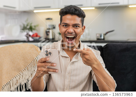 Indian man watches wow video reacts with shock eyes laughs shares link to friends in messenger chat Indian man watches wow video reacts with shock eyes laughs shares link to friends in messenger chat 136573963