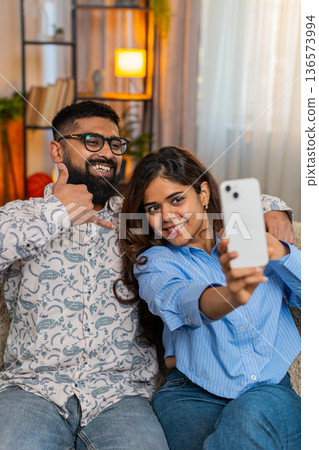Indian family couple man woman taking selfie on smartphone making faces, romantic funny moment 136573994
