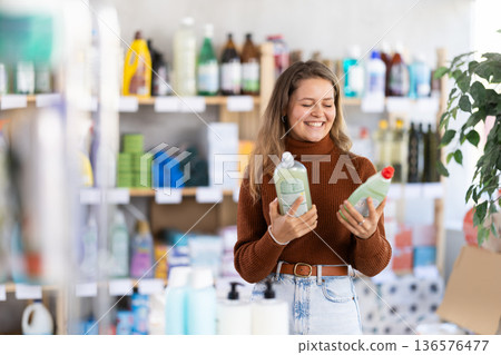 Young woman chooses dishwashing detergent in store 136576477